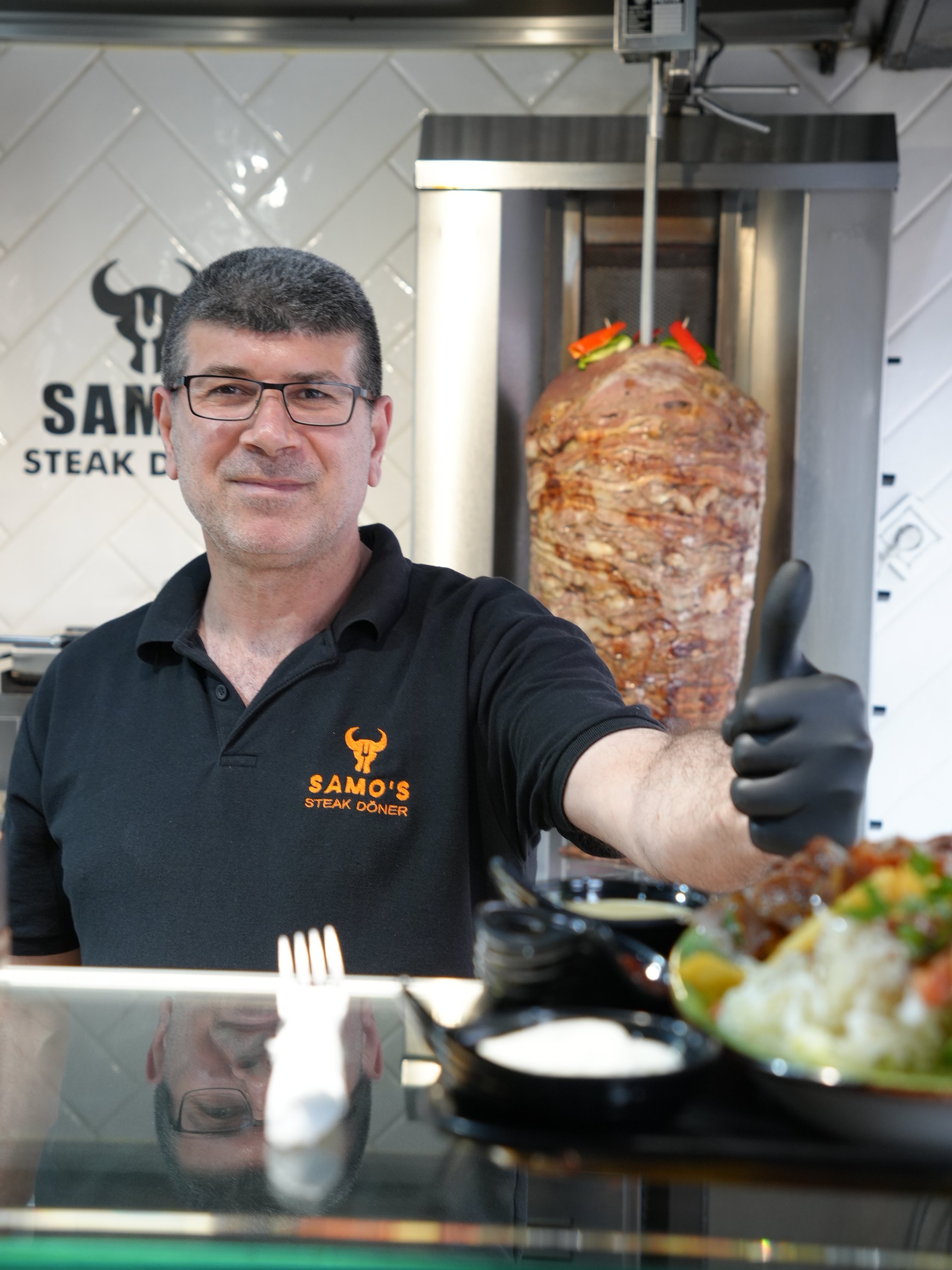 Ein Mitarbeiter von Samos vor dem Steak-Döner-Spieß
